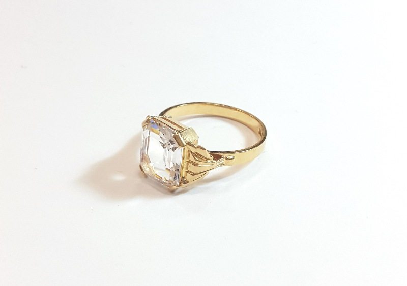 Guld ring med ljus ädelsten, troligtivis diamant.