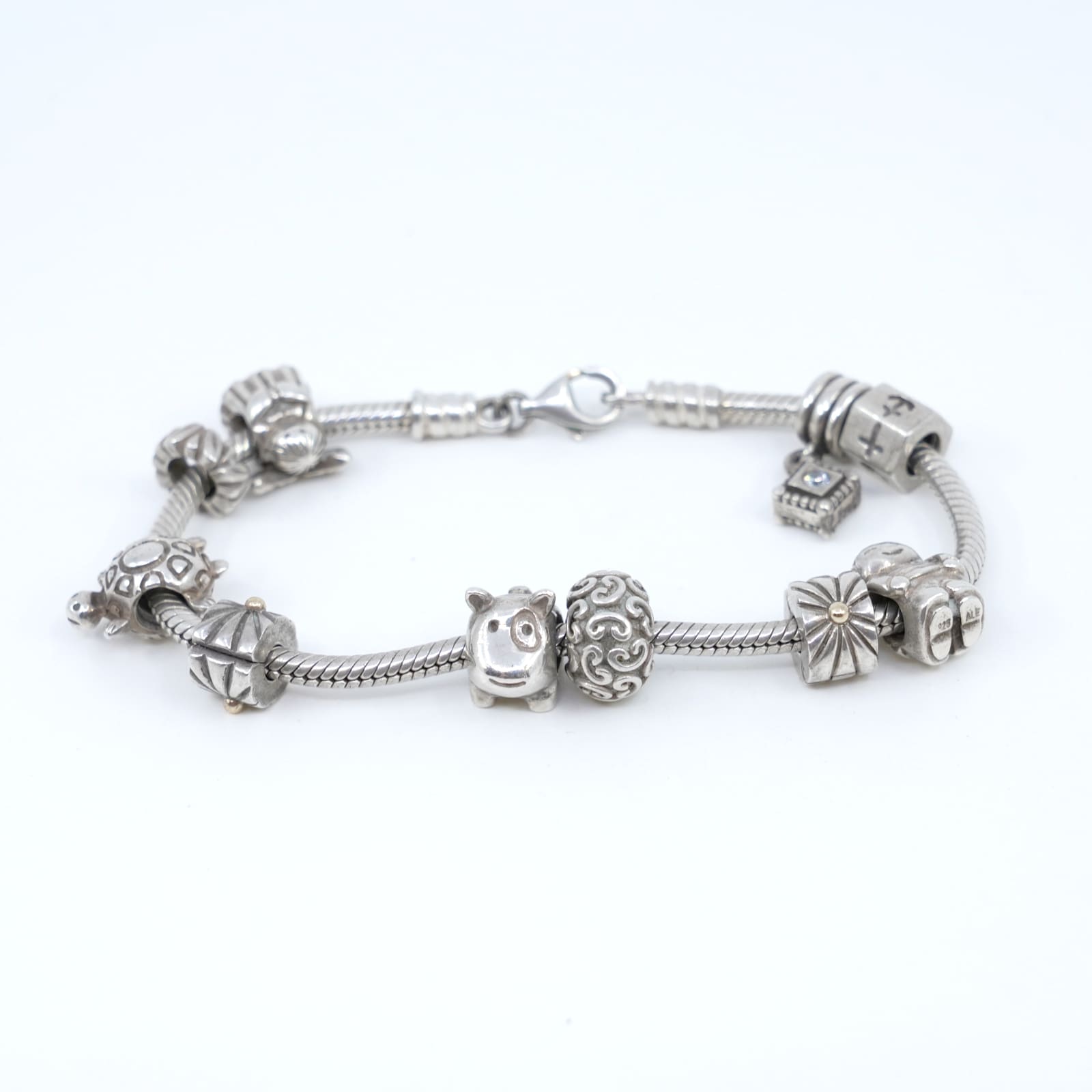 Armband Pandora S925 42,9g Längd 19cm med 8 berlocker och 2 stopp med lite 14K guld på